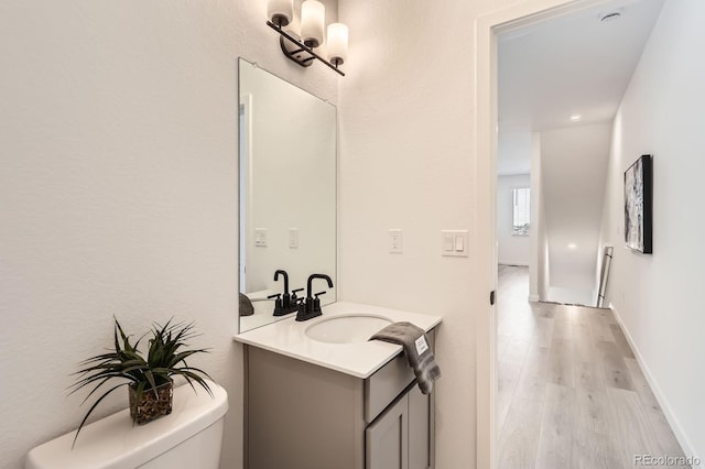 374 N Geneva, Aurora, CO 80010 - half bath featuring toilet, vanity, and wood finished floors