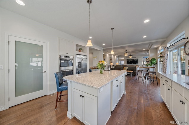 315 Painted Horse Way, Erie, CO 80516 - kitchen featuring appliances with stainless steel finishes, open floor plan, white cabinets, and recessed lighting