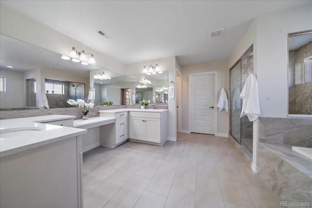 315 Painted Horse Way, Erie, CO 80516 - full bath featuring two vanities, a chandelier, a shower with door, a bathtub, and tile patterned flooring