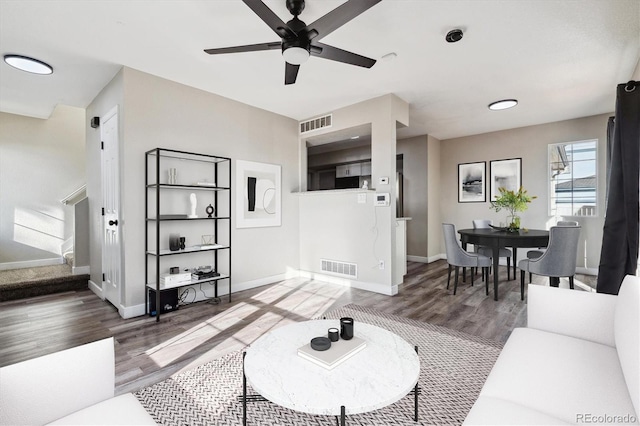 living room featuring ceiling fan and dark hardwood / wood-style flooring