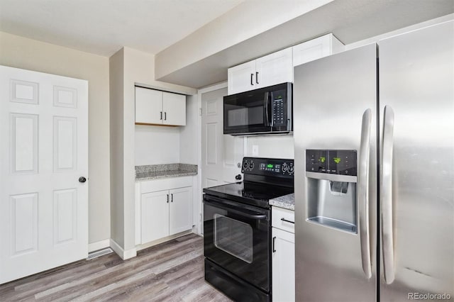 kitchen featuring black appliances, light hardwood / wood-style floors, light stone counters, and white cabinetry