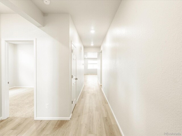 corridor with light hardwood / wood-style flooring