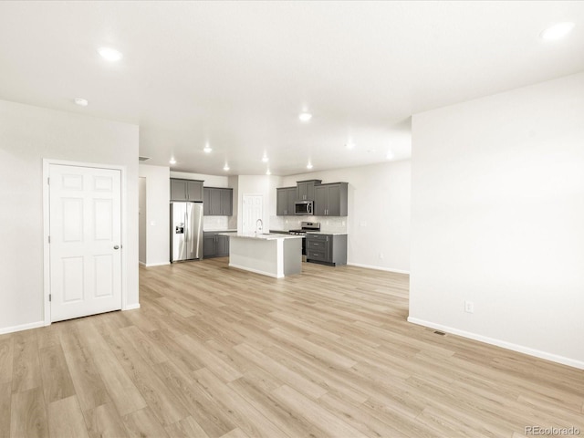 unfurnished living room with light hardwood / wood-style floors and sink