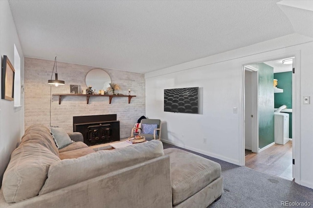 carpeted living area featuring a textured ceiling and an accent wall