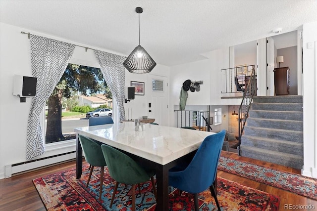 dining room with a baseboard radiator, wood finished floors, stairway, and a textured ceiling