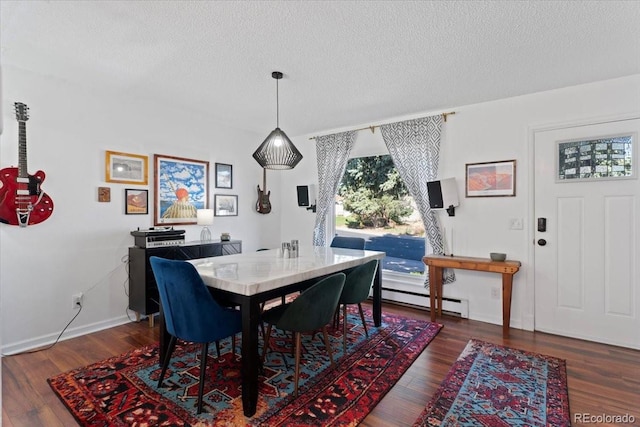 dining space featuring a baseboard heating unit, a textured ceiling, wood finished floors, and baseboards