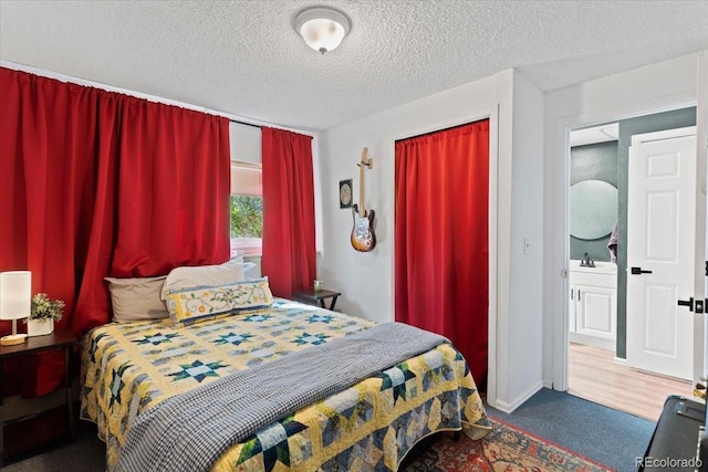 carpeted bedroom with a textured ceiling and a sink