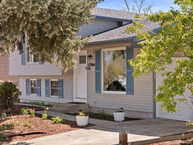 entrance to property with roof with shingles