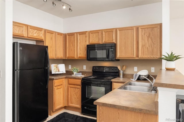 kitchen featuring black appliances, light tile patterned floors, and sink