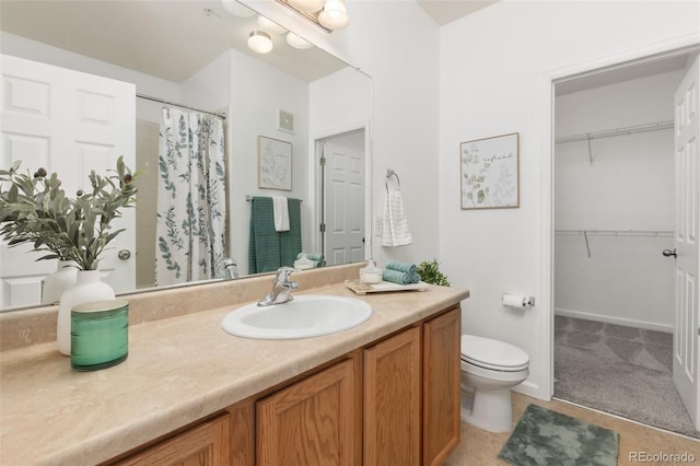 bathroom with tile patterned flooring, vanity, toilet, and walk in shower