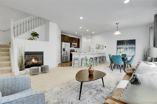 8458 Parkland St, Broomfield, CO 80021 - living area with light carpet, stairs, recessed lighting, and a glass covered fireplace
