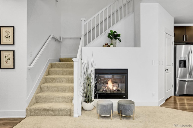 8458 Parkland St, Broomfield, CO 80021 - stairway featuring wood finished floors and a glass covered fireplace