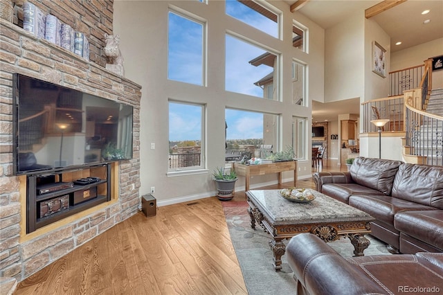 living room with a towering ceiling and light wood-type flooring