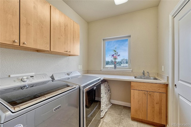 washroom with independent washer and dryer, cabinets, sink, and light tile patterned floors