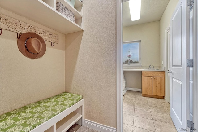 mudroom with light tile patterned floors and sink