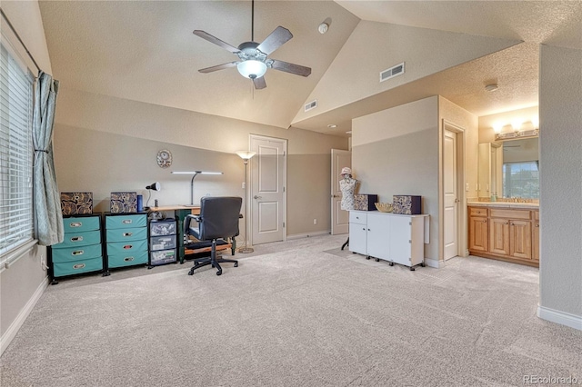 office featuring a textured ceiling, light colored carpet, ceiling fan, and vaulted ceiling