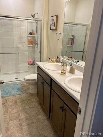 bathroom featuring vanity, a shower with shower door, and toilet