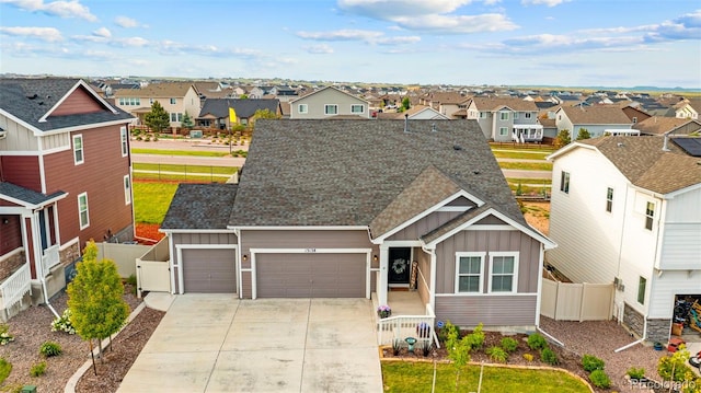 13138 Stoney Meadows Way, Peyton, CO 80831 - view of front of house with board and batten siding, a residential view, a garage, and driveway