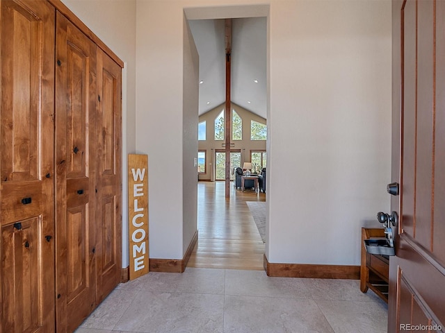 foyer with beam ceiling, recessed lighting, baseboards, and high vaulted ceiling