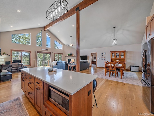 kitchen with stainless steel appliances, light wood-style floors, and open floor plan