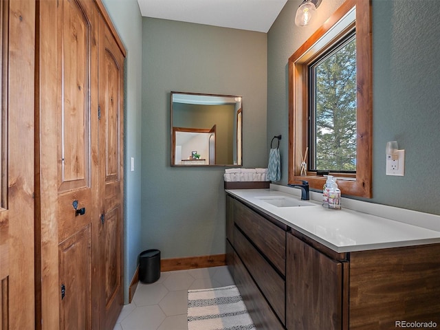 bathroom featuring tile patterned floors, baseboards, and vanity