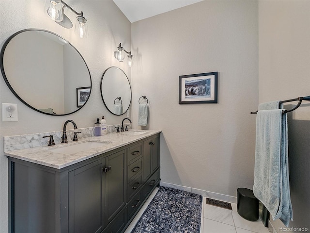 bathroom with double vanity, visible vents, baseboards, and a sink