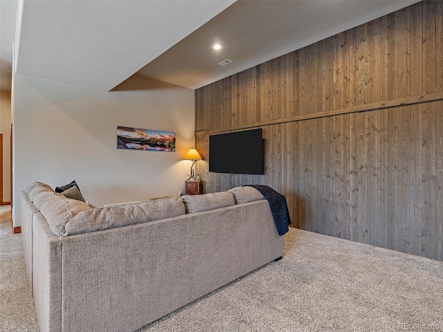 carpeted living area featuring wooden walls, recessed lighting, and visible vents