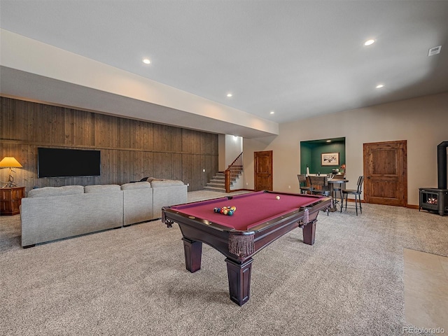 recreation room featuring wooden walls, recessed lighting, a wood stove, and carpet floors