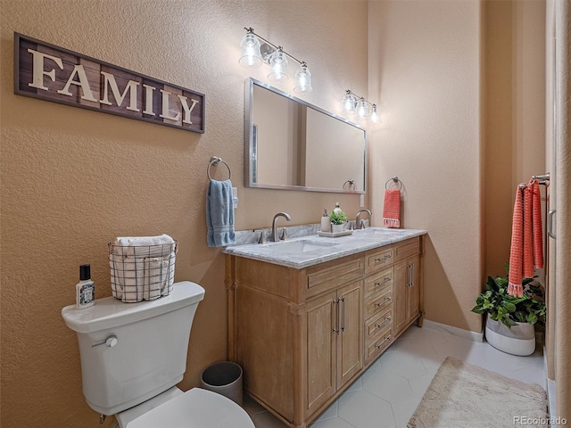 bathroom featuring a sink, toilet, double vanity, and tile patterned flooring