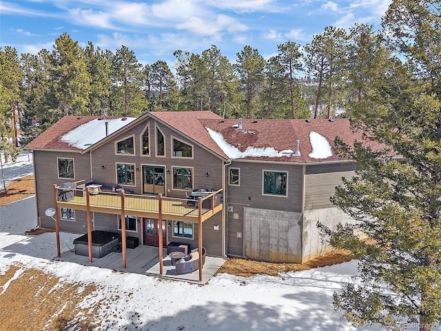 rear view of property with a patio, a fire pit, and a deck