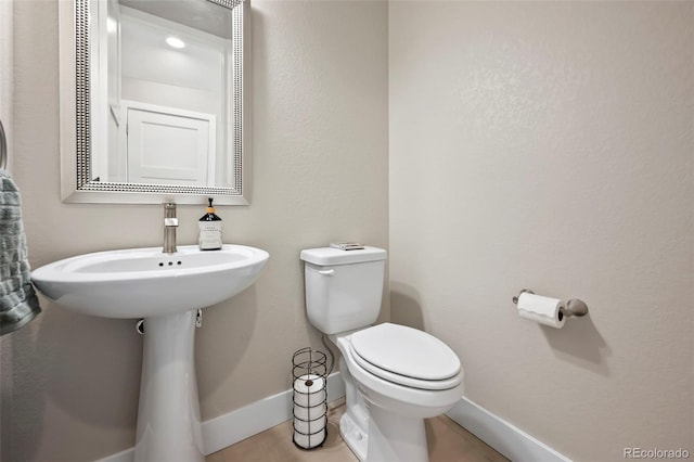 bathroom with toilet and baseboards