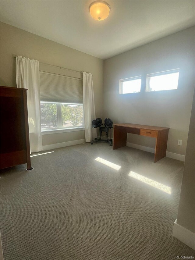 unfurnished office featuring carpet and baseboards