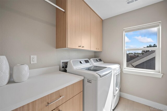 laundry area featuring cabinet space, baseboards, and separate washer and dryer