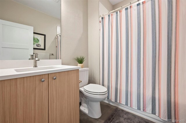 bathroom featuring a shower with shower curtain, vanity, and toilet