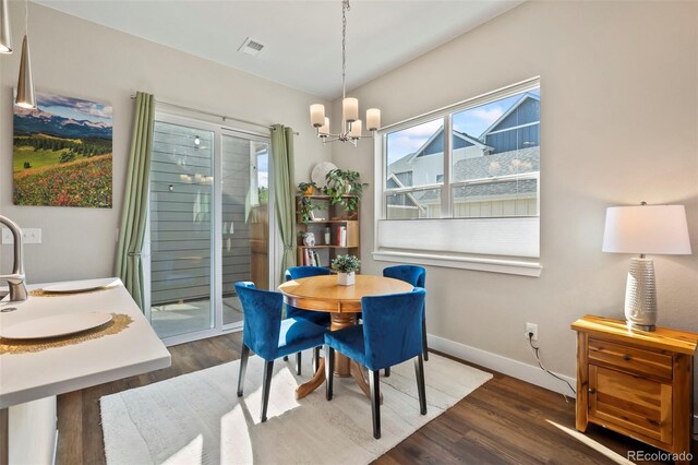 dining area featuring an inviting chandelier, dark wood finished floors, visible vents, and baseboards