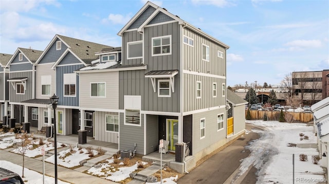 multi unit property with covered porch, a residential view, central AC unit, and board and batten siding