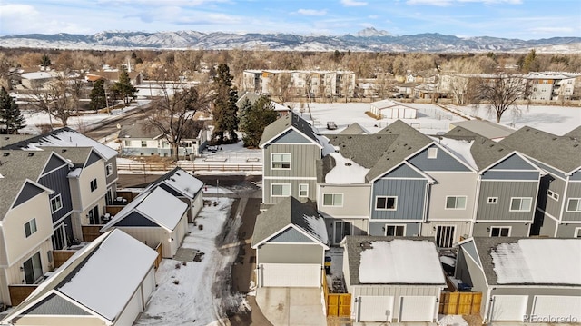 snowy aerial view featuring a residential view and a mountain view