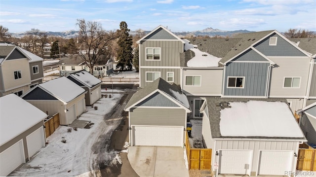 view of front of home featuring an attached garage, a residential view, fence, and board and batten siding