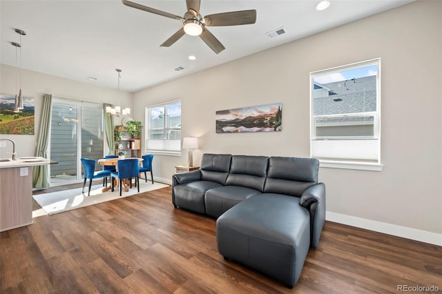 living area with recessed lighting, ceiling fan with notable chandelier, wood finished floors, visible vents, and baseboards