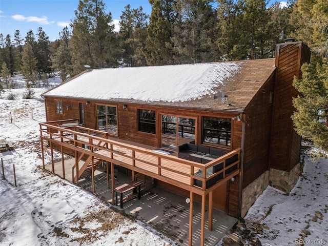 snow covered house with a deck