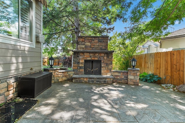 9365 Erminedale Dr, Lone Tree, CO 80124 - fenced backyard with an outdoor stone fireplace and a patio