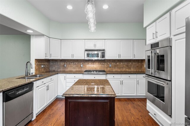 9365 Erminedale Dr, Lone Tree, CO 80124 - kitchen with stainless steel appliances, dark stone countertops, recessed lighting, backsplash, and white cabinets