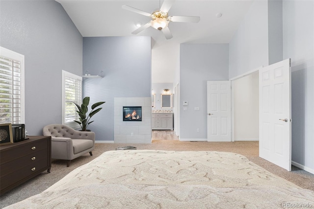9365 Erminedale Dr, Lone Tree, CO 80124 - bedroom with high vaulted ceiling, light carpet, a tile fireplace, ensuite bath, and a ceiling fan