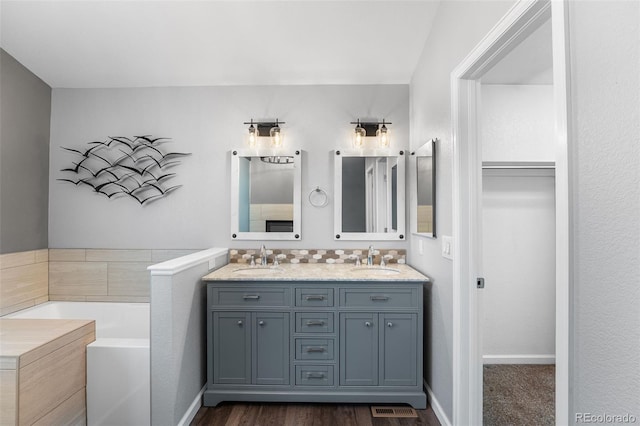 9365 Erminedale Dr, Lone Tree, CO 80124 - full bath with double vanity, a garden tub, and wood finished floors