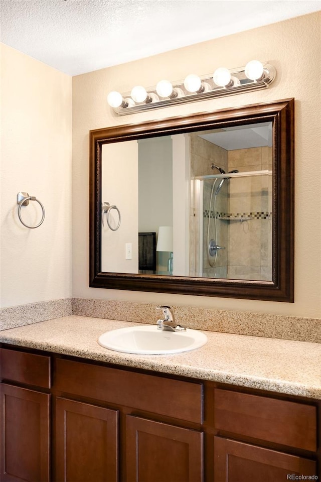 20389 E Powers Pl, Centennial, CO 80015 - full bathroom featuring vanity, a stall shower, and a textured ceiling
