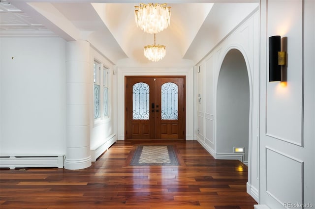 foyer entrance featuring baseboard heating, lofted ceiling, dark hardwood / wood-style floors, and a notable chandelier