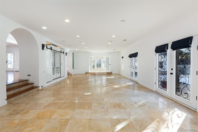 unfurnished room featuring french doors, a barn door, and light tile patterned flooring