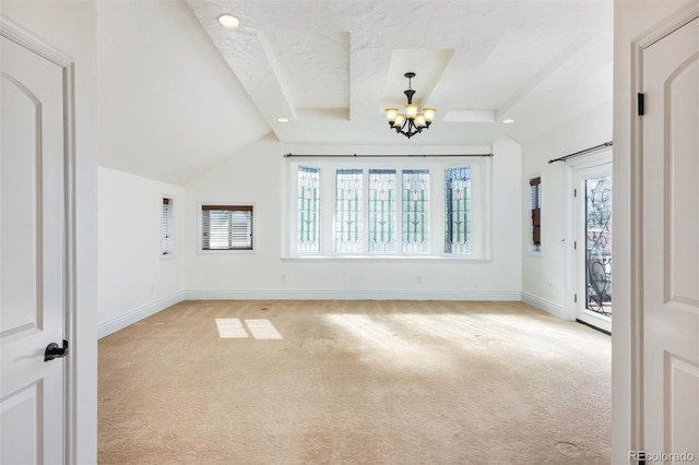 carpeted spare room featuring lofted ceiling, a textured ceiling, and a chandelier