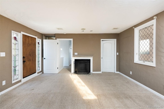 unfurnished living room with a healthy amount of sunlight and light colored carpet