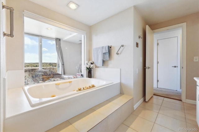 bathroom featuring baseboards, tile patterned flooring, and a whirlpool tub